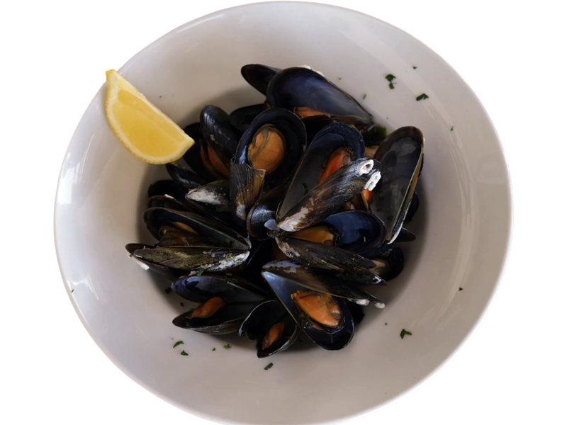Mejillones frescos servidos en un plato blanco, acompañados de una rodaja de limón y decorados con perejil picado. Ideal para amantes de los mariscos.